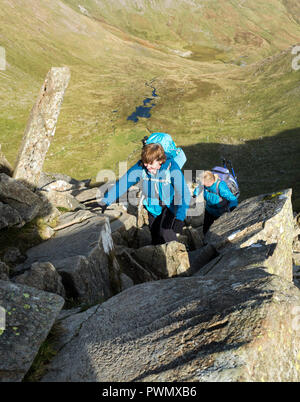 Zwei Menschen, die Kriechen auf Swirral Kante, Helvellyn, Lake District, Cumbria, UK. Stockfoto