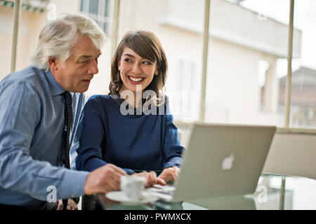 Junge Geschäftsfrau in einer Besprechung mit ihrem Chef zu arbeiten. Stockfoto