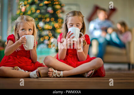 Zwei junge Mädchen trinken heiße Schokolade. Stockfoto