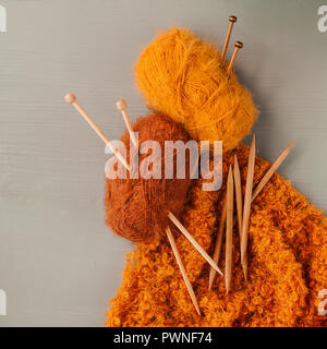 Variety of knitting yarns and knitting needles on grey background. Top view Stockfoto