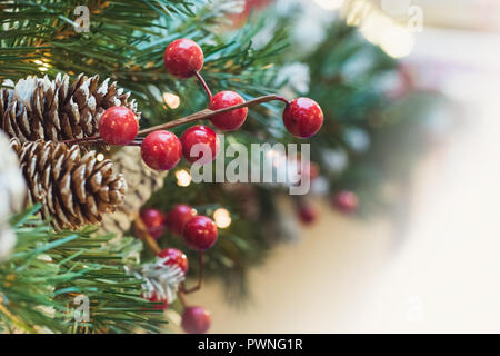 Weihnachtsbaum mit roten Beeren und Kegel als Dekor. Weihnachten. Close Up. Stockfoto