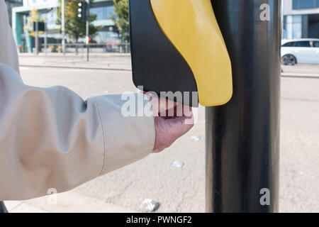 Visuell blinden älteren Mann mit Fußgängerzone Kreuzung Drehkegel Hilfe auf der Unterseite der Push Button Control Box, Dundee, Schottland, Großbritannien Stockfoto