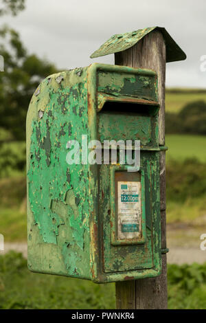 Alten grünen Irischen Post Box mit Peeling Schichten von grüner Farbe auf Holz- Beteiligung an der Landschaft. Stockfoto