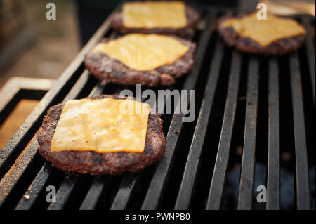 Vorbereitung rind Schnitzel mit Käse für die Burger auf den Grill. Street Food. Stockfoto