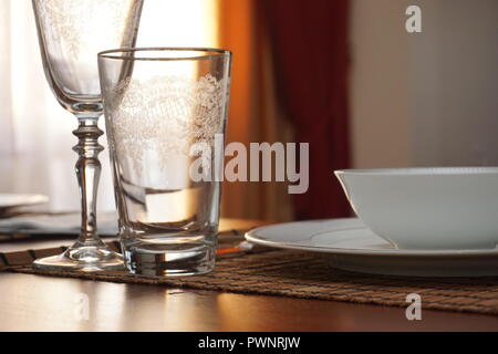 Tisch mit Porzellan Teller und Gläser auf rustikalen Holztisch. Stockfoto