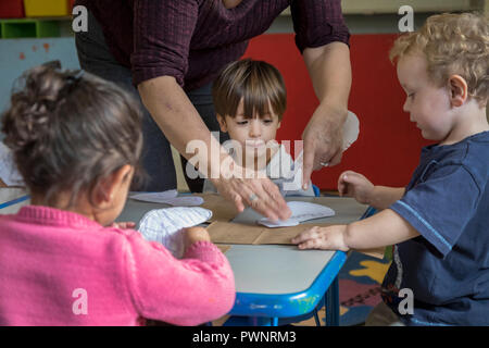 Alpine, Texas - Mari Rodriguez hilft Kindern mit einem Kunstprojekt in der zwei-jährigen Klassenzimmer an der Alpinen Community Center. Das Zentrum ist ein MISSI Stockfoto