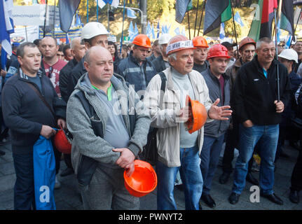 Bergleute halten Fahnen während eines Protestes, vor der Ukrainischen Ministerkabinett der Gebäude in Kiew. Berichten zufolge Tausende Menschen haben bei einem Protest von ukrainischen Trade Union Federation organisiert, fordert, steigende Löhne und Arbeitsbedingungen für Arbeitnehmer, der vom Staat finanziert. Demonstranten tragen Plakate lesen "Bildung ist die Zukunft der Ukraine", "Die nicht in der Schule arbeiten nicht in der Lage ist, uns zu "verstehen", der minimale Lohn ist Gefahr für Ihre Gesundheit", "Notwendigkeit eines Lehrers Gehalt geben, Ukrainische Gesetzgeber" und so weiter. Der Protest auf den Internationalen Tag für die Eradicat Stockfoto