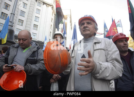 Kiew, Ukraine. 17 Okt, 2018. Bergleute halten Fahnen während eines Protestes, vor der Ukrainischen Ministerkabinett der Gebäude in Kiew. Berichten zufolge Tausende Menschen haben bei einem Protest von ukrainischen Trade Union Federation organisiert, die für die Erhöhung der Löhne, Gehälter und Arbeitsbedingungen für Arbeitnehmer, der vom Staat finanziert. Demonstranten tragen Plakate lesen'' "Bildung ist die Zukunft der Ukraine', '' 'Wer nicht in der Schule arbeiten nicht in der Lage sein, uns zu "verstehen", "Die minimale Gehalt ist Gefahr für ihre Gesundheit',''˜ brauchen ein lehrergehalt an ukrainische Gesetzgeber" zu geben und so weiter. Die Stockfoto