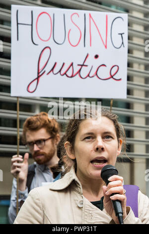 London, Großbritannien. 17. Oktober, 2018. Claire James der Klima gegen den Klimawandel Adressen Tower Block Bewohner und Anhänger der basiskampagne Gruppe Fuel Poverty Action bei einem Protest außerhalb des Ministeriums für Wohnungswesen, Gemeinschaften und lokale Regierung dringend Maßnahmen und Finanzierung zu verlangen Tower Block Bewohner sowohl aus Feuer und Kälte zu schützen. Ein Brief, der von 140 Unterzeichnern, darunter Abgeordnete, Ratsmitglieder unterzeichnet, gewerkschaftlichen Gremien und Gruppen konzentriert sich auf das Gehäuse, Armut, Diskriminierung, Gesundheit, Energie und Klima auch präsentiert wurde. Credit: Mark Kerrison/Alamy leben Nachrichten Stockfoto