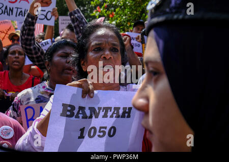 Kuala Lumpur, Malaysia. 17 Okt, 2018. Eine Frau gesehen, riefen Parolen vor einem Polizisten eine gewisse Solidarität bei # Bantah 1050 Kundgebung gegen den Mindestlohn der Malaysischen Arbeiter an Merbok Feld zu Protest zu zeigen. Hunderte von malaysischen Studenten und Arbeiter gemeinsam marschierten für den #Bantah 1050 Kundgebung gegen den malaysischen Arbeitnehmer, Mindestlohn und fordern den Mindestlohn zu RM 1800 anheben zu protestieren. Die neue Regierung in Malaysia hat den Mindestlohn anheben bis zu RM 1050 und wird am 1. Januar 2019 wirksam werden, einschließlich Sabah und Sarawak angekündigt. Die#Bantah 1050 Rallye hatte b Stockfoto