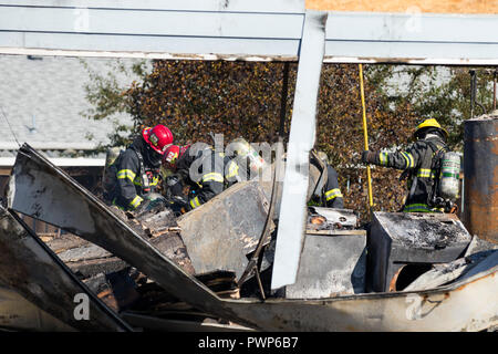 Springfield, Virginia, United States. 17. Oktober, 2018. Eugene/Springfield Feuerwehrmänner bewegen Ablagerungen und spot Brände in einer Abgebrannt Home löschen, nachdem ein Unbekannter schütze Leuchten mehrere Häuser in Brand und dann schießt auf ersthelfer vor seinem eigenen Leben nehmen. Joshua Rainey/Alamy leben Nachrichten Stockfoto