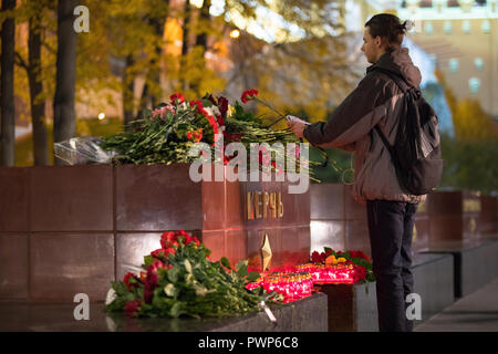 Moskau, Russland. 17. Oktober, 2018. Ein Mann Blumen an den Großen Vaterländischen Krieg Hero City von Kertsch Monument im Alexandergarten, für die Opfer des 17. Oktober 2018 Kertsch polytechnischen Schule Angriff; nach Russlands im Untersuchungsausschuss, die Leichen von 17 Menschen mit Schuß Wunden am Ort des Angriffs und rund 50 Menschen wurden verletzt in der Stadt Kertsch, Krim gefunden wurden. Credit: Victor Vytolskiy/Alamy leben Nachrichten Stockfoto