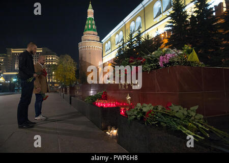 Moskau, Russland. 17. Oktober, 2018. Mans mit Blumen in der Nähe des Großen Vaterländischen Krieges Hero City von Kertsch Monument im Alexandergarten, für die Opfer des 17. Oktober 2018 Kertsch polytechnischen Schule Angriff; nach Russlands im Untersuchungsausschuss, die Leichen von 17 Menschen mit Schuß Wunden wurden auf der Website der Angriff und rund 50 Menschen wurden verletzt in der Stadt Kertsch, Krim gefunden. Credit: Victor Vytolskiy/Alamy leben Nachrichten Stockfoto