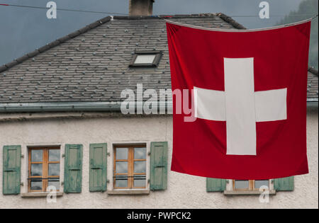Schweiz, Wallis, die Region von Sierre und Val d'Anniviers, Dorf von Château-Gontier. Typisches Haus und Schweizer Flagge. Stockfoto