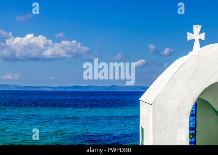 Kleine Kirche, traditionelle Kapelle über dem Sandstrand an das Ägäische Meer und den Berg Athos. Stockfoto