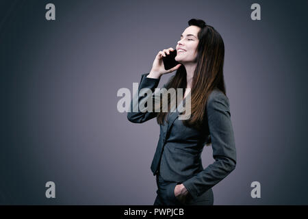 Portrait einer jungen lächelnd Geschäftsfrau am Telefon Stockfoto