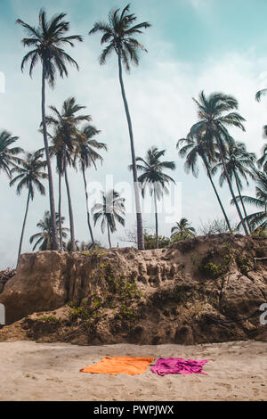 Rosa und Orange Handtücher auf den unberührten weißen Sandstrand von Tayrona Nationalpark durch den Dschungel an der karibischen Küste Kolumbiens umgeben Stockfoto