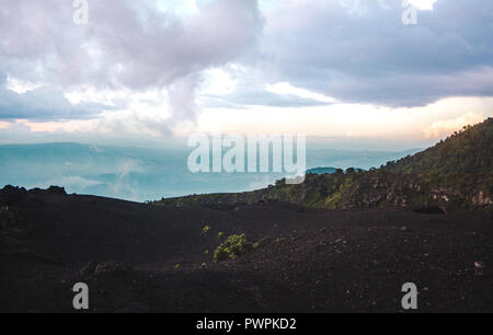 Wechselnde Landschaften rund um den Vulkan Pacaya, einer der aktivsten Vulkane Guatemalas, aus schwarzem Vulkangestein zu üppig grüne Wälder bei Sonnenuntergang Stockfoto