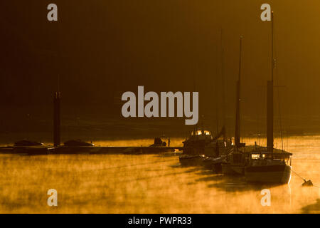 Die Sonne über dem Fluss Medway und seiner Schiffe auf dem Fluss Medway Stockfoto