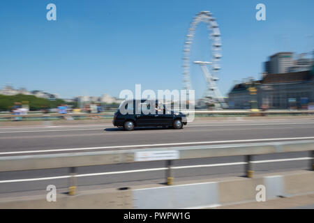 LONDON/ENGLAND - 26. Juni 2018: Black Cab ist einer Fahrt entlang der Westminster Bridge und Coca-Cola London Eye auf Hintergrund Stockfoto
