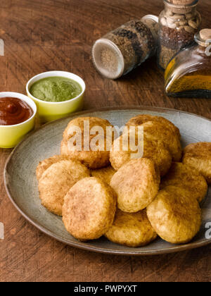 Kartoffel Bälle/TIKKI FRITTIERT, serviert mit RAGDA, Zwiebeln, Koriander, & TERMINE CHUTNEY Stockfoto