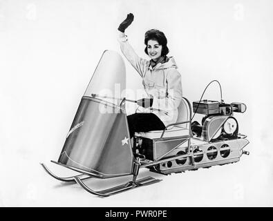 Snowmobile in den 1950er Jahren. Die junge Frau ist das Fahren mit einem schneemobil Modell Winter Junge in den 1950er Jahren. Die Zweitaktmotoren gasolin Motor ist auf der Rückseite montiert. Stockfoto