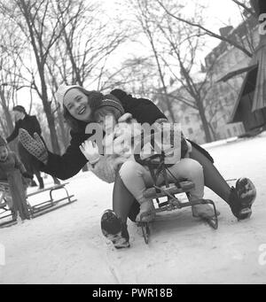 Winter in den 1940er Jahren. Eine junge Mutter und ihre Tochter sitzt auf einem Schlitten und sind Verzicht auf jemanden. Schweden 1940. Foto Kristoffersson Ref F 132-2 Stockfoto