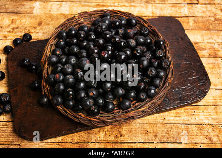 Aronia Beeren in eine Holzkiste, Ansicht von oben, gesundes Essen Stockfoto