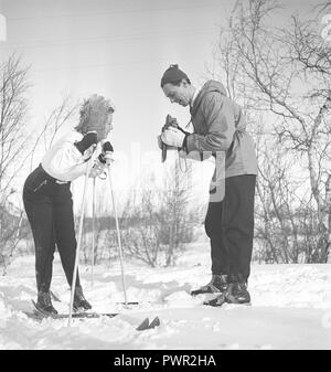 Winter in den 1940er Jahren. Schauspieler Nils Kihlberg, 1915-1965 ist hier mit seiner Frau Ann-Britt. Er nimmt Bilder von ihr auf ihren Winterurlaub. Sie sind beide trugen Winterkleidung und Skier. Die Kamera ist ein von der deutschen Firma Rollei Rolleiflex. Schweden 1940. Foto Kristoffersson Ref D 97-1 Stockfoto