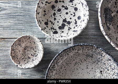 Ton Handwerk leere Schalen, Teller, bedeckt mit glasierten, unter Text auf grauem Hintergrund aus Holz. Flach Stockfoto