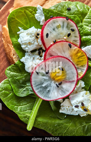 Licht gesund Sandwiches mit Brot, Toast, Käse und frisch gesammelten organischen Radieschen, Spinat auf einem Holzbrett. Close-up Stockfoto