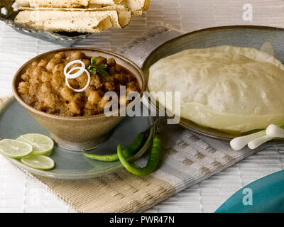 CHOLE BHATURA mit PAPAD SERVIERT MIT Limette, Zitrone, Zwiebeln, grüne Chilis/KICHERERBSEN mit gebratenen indisches Brot Stockfoto