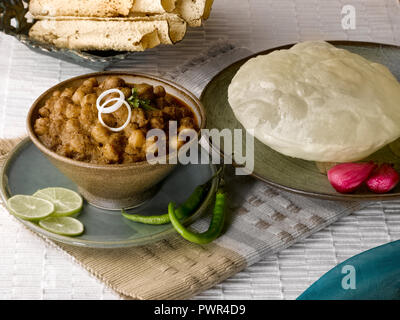 CHOLE BHATURA mit PAPAD SERVIERT MIT Limette, Zitrone, Zwiebeln, grüne Chilis/KICHERERBSEN mit gebratenen indisches Brot Stockfoto