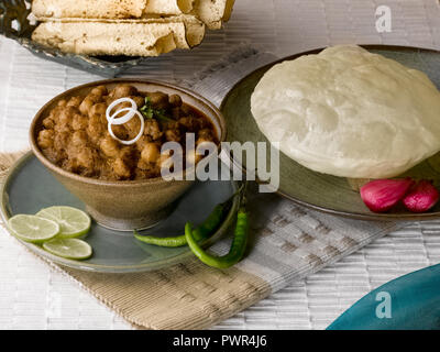 CHOLE BHATURA mit PAPAD SERVIERT MIT Limette, Zitrone, Zwiebeln, grüne Chilis/KICHERERBSEN mit gebratenen indisches Brot Stockfoto