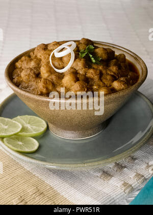 CHOLE BHATURA mit PAPAD SERVIERT MIT Limette, Zitrone, Zwiebeln, grüne Chilis/KICHERERBSEN mit gebratenen indisches Brot Stockfoto