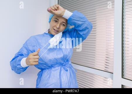 Portrait von müde Chirurg Frau in einem sterilen blauen Anzug. Stockfoto