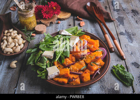 Gebratene Kürbisscheiben, Spinatblätter, Camembert Brie Käse, Cashewkerne, Sauce. Vegetarische Salat, Geschirrspüler Stockfoto