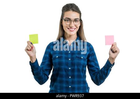 Junge Frau trifft eine Auswahl. Foto isoliert ist, Frau hält zwei sauber Aufkleber in verschiedenen Farben, Platz für Ihren Text. Stockfoto