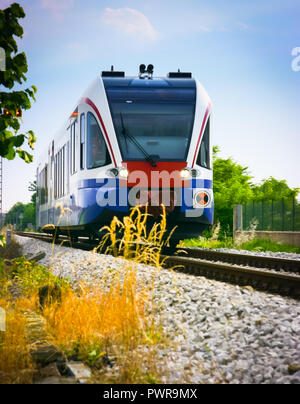 Low Angle Blick auf einen Pendlerzug in der Landschaft, Udine, Friaul-Julisch-Venetien, Italien, Udine, Friaul, Italien Stockfoto