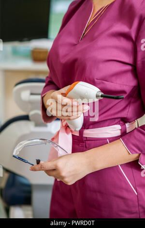 Zahnarzt stehend mit Dental instruments in einem Zahnarztbüro Stockfoto