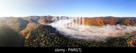 Magische Schönheit der Karpaten. Morgen Nebel erstreckt sich über den Fluss und die Berge. Atemberaubende Landschaft. Herbst Zeit, U Stockfoto