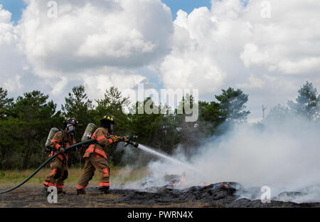 96. Test Wing Feuerwehrmänner Schlacht Feuer um eine simulierte Hubschrauberabsturz während einer Messe Unfallversicherung Übung 3 in Eglin Air Force Base, Fla. Die gemeinschaftsweite übung tief in den Eglin Bereich umfasste 96 TW Ersthelfer, 6 Ranger Training Bataillon Personal, Okaloosa County Ersthelfer unter anderem. Die übung ausgewertet Ranger Aktionen und Base und lokale Antworten auf beide ein Blitzschlag und Absturz eines Hubschraubers. (U.S. Air Force Foto/Samuel King Jr.) Stockfoto