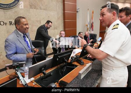 RIVERSIDE, Kalifornien (20. Juni 2017) Kapitän Corry Shedd, Executive Officer der Naval Surface Warfare Center (NSWC), Corona Division, rechts, Chats mit Chuck Washington County von Riverside dritten Bezirk Supervisor und ehemaligen naval Aviator, bevor die Mission in der Grafschaft von Riverside Aufsichtsrat aktualisieren. Shedd der Vorstand auf ihren Antrag auf die erhöhte Nachfrage nach einzigartigen NSWC von Corona Mission zu ermöglichen warfighters zu trainieren, durch Messung, Analyse und unabhängige Bewertung kämpfen und zu gewinnen, sowie dem Befehl und dem wachsenden wirtschaftlichen und sozialen Beiträge zu der Region aktualisiert. ( Stockfoto