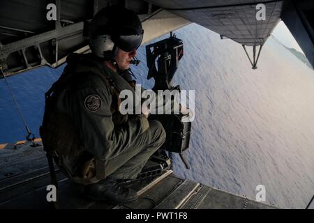 Us Marine Corps Sgt. Cole Bennick, Hubschrauber Crew Chief, schweren Helikopter Squadron 462 (HMH-462), 3 Marine Flugzeugflügel, als Teil der Einheit Deployment Program bereitgestellt, mit 1St Marine Flugzeugflügel, führt Antenne schießwesen Ausbildung, Okinawa, Japan, 27. Juni 2017. HMH-462 durchgeführt werden mehrere Übungen ihr Wissen und ihre Bereitschaft, sich an den Einsatz der Luftfahrt Waffen und Taktiken. Stockfoto