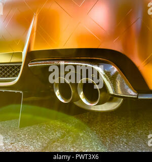 Doppelte Auspuffrohr einer orange Auto mit Lens flare Stockfoto