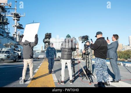 SYDNEY (1. Juli 2017) Kapitän Larry McCullen, kommandierender Offizier der Amphibisches Schiff, die USS BONHOMME RICHARD (LHD 6) spricht mit den Gastgebern 9 Nachrichten, eine australische Fernsehen morgen zeigen, aus dem Schiff Flight Deck während einer Live-Übertragung. Bonhomme Richard machte einen Port zu Sydney als Teil der Talisman SABRE 2017, der eine zweijährige USA - Australien bilaterale militärische Übung, verbindet ein Feld Training und Kommandostellenübung Interoperabilität und zur Stärkung der Grundsätze der amerikanisch-australische Bündnis zu wahren. Stockfoto