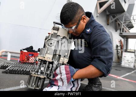 Nordsee (22. Juni 2017) - der Gunner Mate 3. Klasse Jan Rojas, aus Long Island, New York, führt die routinemäßige Wartung, die mit dem MK 38 machine gun System an Bord der Arleigh-Burke-Klasse geführte Anti-raketen-Zerstörer USS James E. Williams (DDG95) Juni 22, 2017. James E. Williams, home-in Norfolk, Virginia portiert, ist auf eine Routine, um die Bereitstellung zu den USA 6 Flotte Bereich der Maßnahmen zur Unterstützung der US-amerikanischen nationalen Sicherheitsinteressen in Europa. Stockfoto