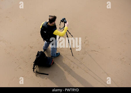 Landschaft Fotograf auf Saltburn Strand Einrichtung seine Kamera auf einem Stativ auf Saltburn Strand Stockfoto