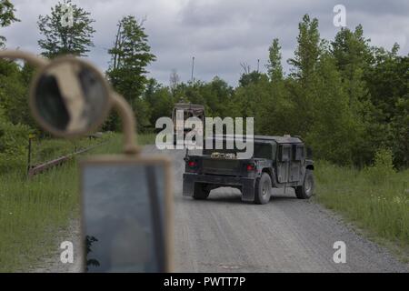 Us-Soldaten mit Echo Company, 186th Brigade Support Battalion, 86th Infantry Brigade Combat Team (Berg), Vermont National Guard, ihre Fahrzeuge in Reaktion auf eine simulierte IED in Fort Drum, N.Y., 19. Juni 2017. Die 186Th BSB durchgeführt Konvoi live fire Übungen während ihrer jährlichen Schulungen Bereitschaft zu unterstützen. Stockfoto