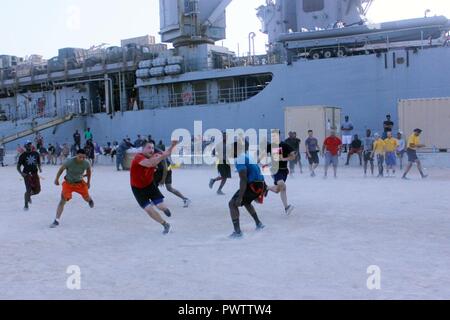 DUQM, Oman (13. Juni 2017) Matrosen zu den Amphibischen dock Landung Schiff USS Carter Hall (LSD 50) und Marines auf den 24 Marine Expeditionary Unit zugewiesen, die in einem Captain cup Flag football Spiel während einer port Besuch teilnehmen. Carter Hall, Teil der Bataan amphibischen bereit, Gruppe, ist in die USA 5 Flotte Bereich für Maßnahmen zur Erhöhung der Sicherheit im Seeverkehr im Einsatz Verbündeten und Partnern zu beruhigen, und der Freiheit der Schiffahrt und des freien Handels in der Region erhalten. ( Stockfoto